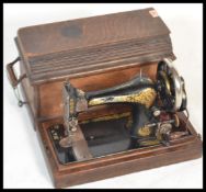 A early 20th Century oak cased singer sewing machine. The sewing machine decorated with gilt