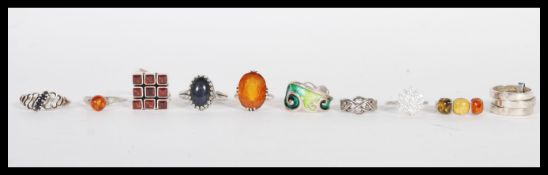 A selection of silver rings to include stamped 925 rings such as a square head ring with orange
