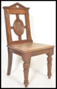 A Victorian 19th century solid mahogany hall chair raised on turned legs with solid panel seat