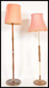 A 1970's teak wood standard lamp raised on terraced base with turned column and tapering shade