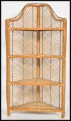 An early 20th century rattan weave ebony lined corner whatnot / etagere having 4 shelves with an