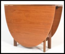 A 1970's 20th century Nathan teak wood drop leaf dining table. The full length drop leaves being