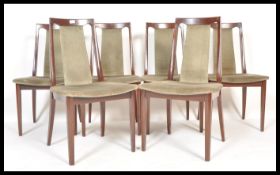 A set of 1970's retro dark teak wood G-Plan style dining chairs being raised on squared legs with