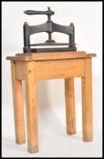 A 19th Century Victorian cast iron book press of typical form raised on a solid oak frame / stand