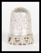 A early 20th century silver hallmarked thimble, having engraved decoration with pierced rim to