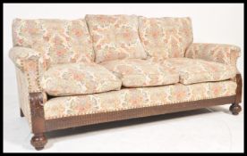 A 1920's Chesterfield 3 seat sofa settee being raised on bun feet with castors having barrel arms