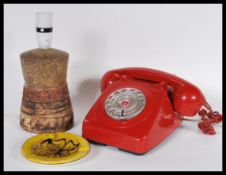 A vintage 20th century BT ring dial telephone in a red colourway together with a Poole pottery