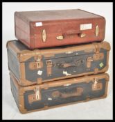 A vintage stack of suitcases dating from the 20th century to include leather and two tone examples
