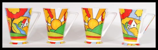 A group of four Past Times Clarice Cliff Art Deco style tea cups of conical form having shaped