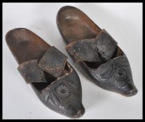 A pair of 19th Century Dutch wooden clogs having carved floral details complete with original