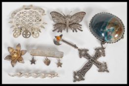 A collection of silver brooches to include one in the from of an axe with a orange stone to the top,