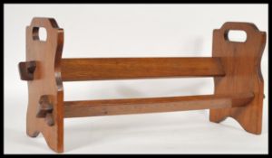 A 1920's oak book trough stand having pierced twin handles sides, angled trough / book rest to