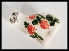 A 20th Century signed Wemyss ceramic brooch in the form of a cat having hand painted roses and