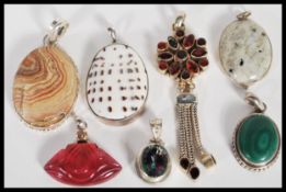 A selection of silver and precious stone pendants to include a stamped 925 flower pendant set with