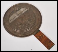 A 19th century Japanese bronze hand mirror having cane wrapped handle. The central circular mirror
