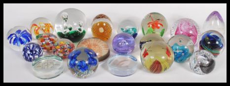 A collection of 20th century glass paperweights to include a pink Caithness control bubble swirl