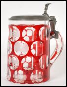 A fantastic 19th Century German cranberry glass stein having etched faceted decoration depicting