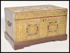 A 19th Century Zanzibar brass studded and armorial decorated trunk chest having large brass panel