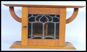 A 19th Century Arts and Crafts light oak Victorian smokers cabinet raised on a plinth base with