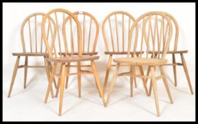 A set of 6 mid century Ercol beech and elm wood hoop back dining chairs. Raised on turned legs