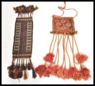 A Wasam camel belt from Oman having a brown ground with geometric patterning and orange and black