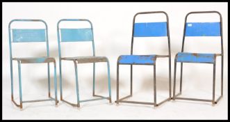 A set of four vintage retro 20th Century stacking chairs raised on tubular supports with panel seats
