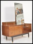 A 1960's Ernest Gomme ( early G-Plan ) tola teak wood drop centre dressing table chest. Raised on