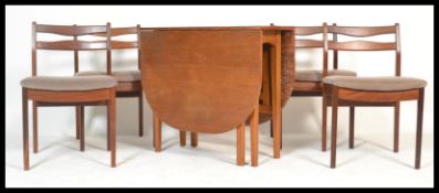 A retro 20th Century teak wood drop leaf gate leg dining table together with a set of four rail back