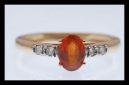 A hallmarked 9ct white gold prong ring set with an oval cut brown stone having white accent stones