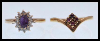 A hallmarked 9ct gold wishbone ring set with four small red stones (hallmarked Birmingham, size