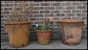 A collection of three 20th century garden terracotta plant pots in red colour. The  large pair