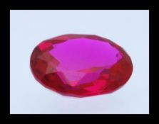 A Synthetic oval faceted cut ruby stone being red in colour, measuring 10.1mm high x 8mm wide x 4.