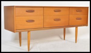 A mid century teak wood Danish influence sideboard credenza. Raised on tapering legs with a series