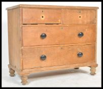 A Victorian pine 2 over 2 cottage chest of drawers being raised on turned legs with 2 short