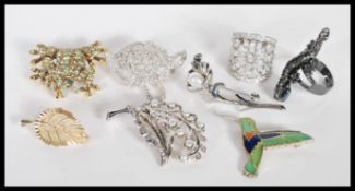 A collection of vintage costume jewellery brooches and rings to include a brooch in the form of a
