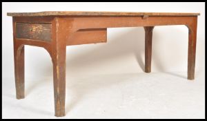 A large 19th century pine farmhouse refectory dining table being raised on squared legs having a