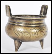 A 19th Century Chinese bronze censer ding prayer bowl raised on three sharp feet with shaped handles