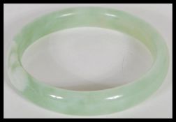 An early 20th Century Chinese carved green stone jade type bangle of circular form. Inside