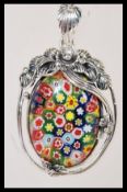 A sterling silver necklace pendant having central millefiori glass panel and floral mount set to