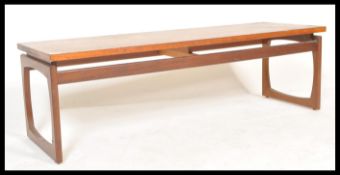 A mid century Danish Influence teak wood large ' long john ' coffee table being raised on squared