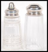Two early 20th Century Art Deco hallmarked silver lidded and cut glass sugar shakers or casters each