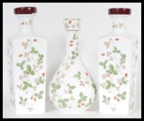 A garniture set of three 20th Century Wedgwood ceramic decanters in the 'Wild Strawberry' pattern,