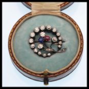 A 19th Century Victorian ruby, diamond and sapphire brooch prong set with three old cut diamonds,