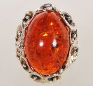 A large sterling silver dress ring in the Art Nouveau style having floral monts with large faux