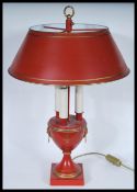 A Louis XVI Bouillotte three light candelabra coaching lamp on a round base with a terracotta