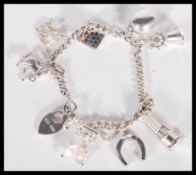 A sterling silver charm bracelet consisting of eight various charmes, to include a house and a