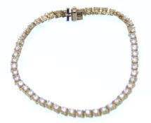 A gold and diamond tennis bracelet. The bracelet b