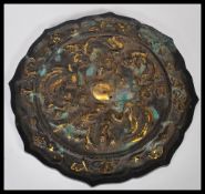 A Chinese 19th Century bronze mirror having emboss
