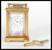 An 8 day brass cased miniature carriage clock having hand painted Limoges enamel porcelain