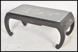 A Chinese black lacquer coffee table raised on scrolled legs with single drawer to front having